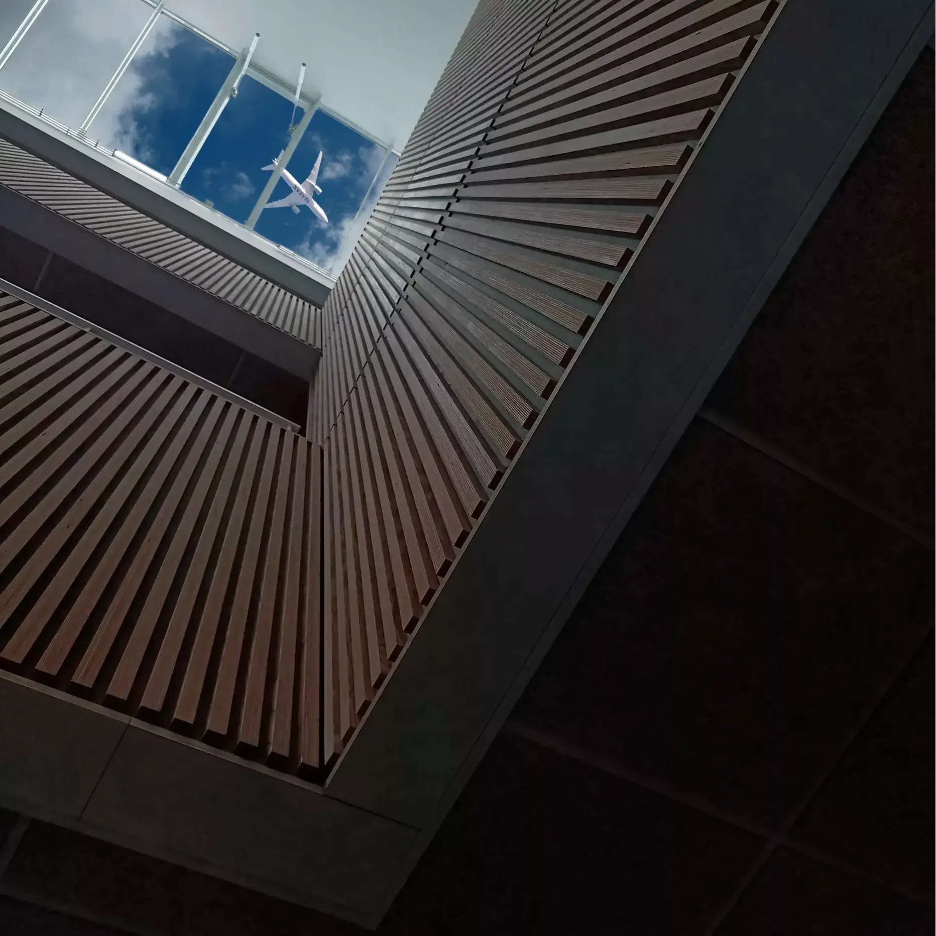 Billede af Agora på UCL Seebladsgade Odense, hvor der er redigeret et billede af et fly og en himmel ind.